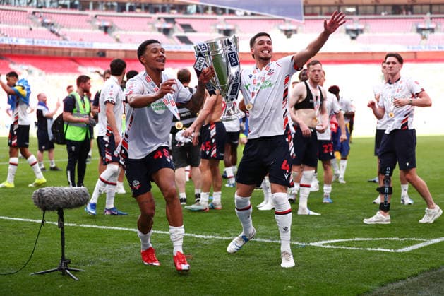 London, England, 24th May 2026. Mason Burstow of Bolton Wanderers and Xavier Simons of Bolton Wanderers lift the trophy following victory during the Bolton Wanderers vs Stockport County Sky Bet League 1 play off final match at Wembley Stadium, London. Picture credit should read: Jake Youle Sportimage EDITORIAL USE ONLY. No use with unauthorised audio, video, data, fixture lists, club league logos or live services. Online in-match use limited to 120 images, no video emulation. No use in betting, games or single club league player publications. SPI_060_JY_Stockport_County_Bolton_Wanderers SPI-4821-0060