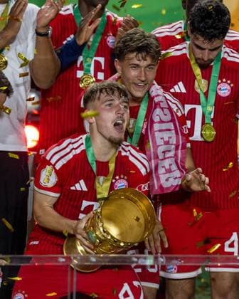 Fußball, Herren, Saison 2025 2026, 83. DFB-Pokal-Finale, FC Bayern München - VfB Stuttgart (3:0), v. l. Lennart Karl (Bayern München), Tom Bischof (Bayern München) bei der Siegerehrung mit Pokal, 23.05. 2026, Copyright: xMatthiasxKochx