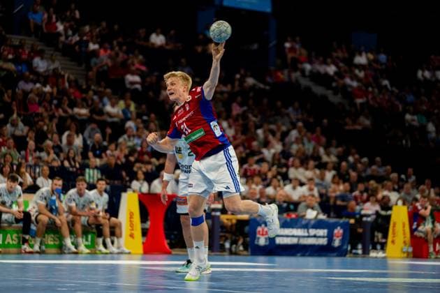 Frederik Bo Andersen wirft den Ball aus der Luft mit ausgestrecktem Arm zum Tor. Der Spieler des HSV Hamburg trägt sein rotes und blaues Heimtrikot und agiert vor vollbesetzten Rängen in der Barclays Arena. Handball Verein Hamburg vs. Frisch Auf Göppingen Copyright: xPhilippHeistx