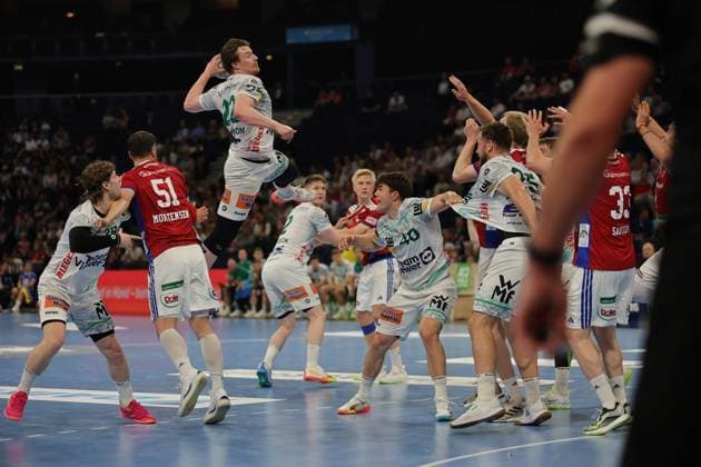 Frederik Bo Andersen springt zum Wurf ab und wird dabei von Abwehrspielern der Göppinger bedrängt. Die Szene zeigt eine intensive Spielsituation in der Barclays Arena mit vollem Einsatz beider Teams. Frederik Bo Andersen ( 21; HSV Hamburg) bei Sprungwurf gegen Frisch Auf Göppingen