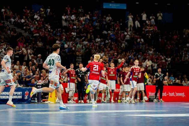 Frederik Bo Andersen ( 21; HSV Hamburg) im roten Trikot läuft mit dem Ball während der Partie in der Barclays Arena. Im Hintergrund sind Spieler beider Mannschaften und die Zuschauer im Stadion zu sehen. Handball Verein Hamburg vs. Frisch Auf Göppingen Copyright: xPhilippHeistx