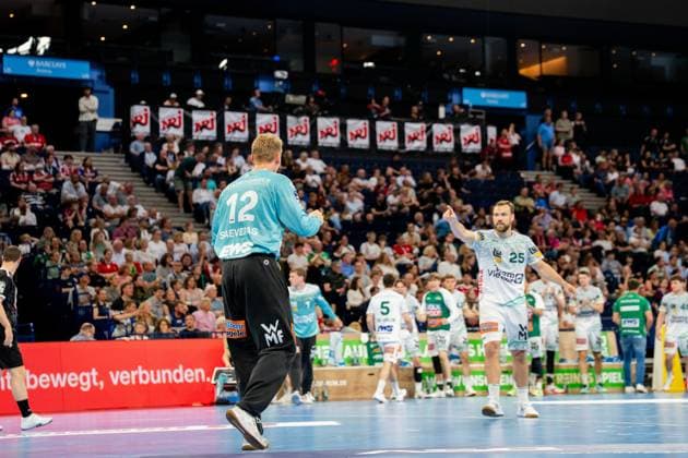 Kristian Saeveras trägt das hellblaue Trikot von Frisch Auf Göppingen und bewegt sich auf dem Spielfeld der Barclays Arena. Mehrere Spieler beider Teams sind in der Spielszene positioniert, während Zuschauer die Partie verfolgen. Handball Verein Hamburg vs. Frisch Auf Göppingen Copyright: xPhilippHeistx
