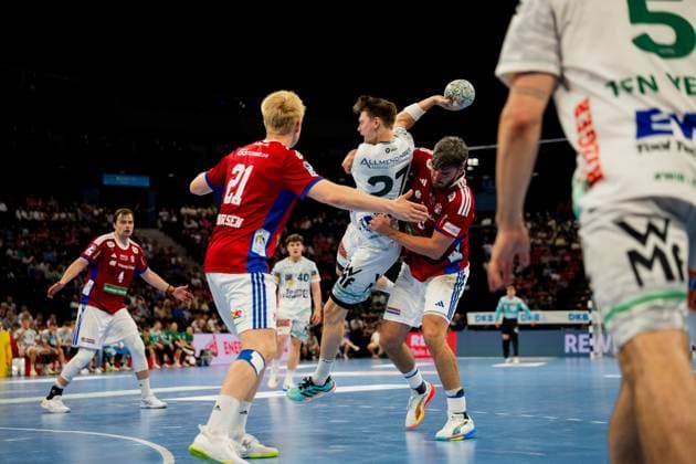Spieler von Frisch Auf Göppingen (weiß) und HSV Hamburg (rot) kämpfen um den Ball in der Luft während der Bundesliga-Partie in der Barclays Arena. Der Göppinger Spieler 27 versucht, den Ball über die Abwehr hinweg zu werfen, während zwei Hamburger Defensivspieler den Angriff blockieren. Handball Verein Hamburg vs. Frisch Auf Göppingen Copyright: xPhilippHeistx