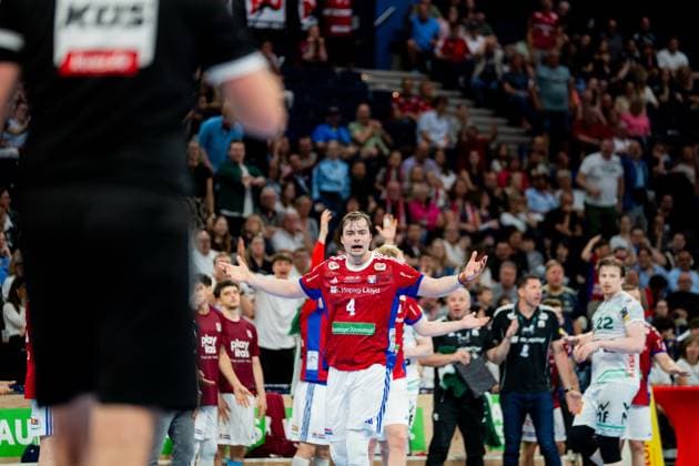 Andreas Magaard steht mit ausgebreiteten Armen auf dem Spielfeld, während der Ball oben im Bild sichtbar ist. Im Hintergrund sind Spieler beider Mannschaften und Zuschauer in der vollbesetzten Barclays Arena zu sehen. Handball Verein Hamburg vs. Frisch Auf Göppingen Copyright: xPhilippHeistx