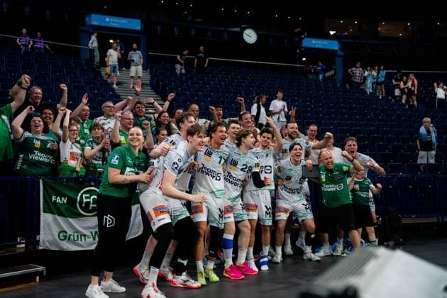 Spieler von Frisch Auf Göppingen in weißen Trikots feiern zusammen mit Fans und Betreuern in der Barclays Arena. Die Mannschaft und Anhänger bejubeln gemeinsam den Erfolg nach dem Spiel gegen HSV Hamburg. Handball Verein Hamburg vs. Frisch Auf Göppingen Copyright: xPhilippHeistx