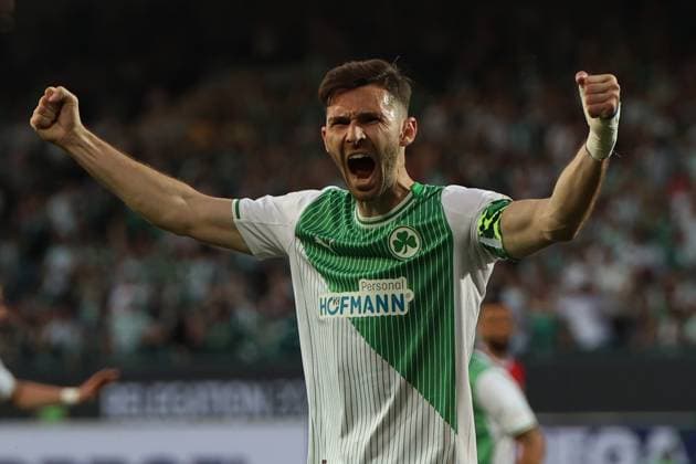 Ein Spieler der SpVgg Greuther Fürth reißt beide Arme hoch und schreit seinen Jubel heraus. Die Trikotnummer ist nicht erkennbar, im Hintergrund ist ein weiterer Spieler zu sehen. SpVgg Greuther Fürth Spieler bejubelt Tor mit geballten Fäusten