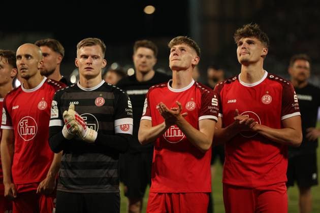 Jakob Golz ( 1; Rot-Weiss Essen) und Tobias Kraulich ( 33; Rot-Weiss Essen) stehen gemeinsam mit weiteren Spielern von Rot-Weiss Essen auf dem Platz und klatschen in Richtung der Fans. Die Spieler wirken emotional bewegt nach dem Abpfiff. Jakob Golz ( 1; Rot-Weiss Essen) und Tobias Kraulich ( 33; Rot-Weiss Essen) beim Applaus