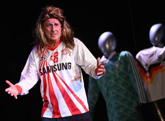 26.05.2026 ,xophax, Köln , Cologne,Fussball , Fussballer Pierre Littbarski .Litti macht Theater, Volksbühne am Rudolfplatz. Pierre Littbarski mit FC - Trikot auf der Bühne. Koeln