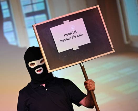 26.05.2026 ,xophax, Köln , Cologne,Fussball , Fussballer Pierre Littbarski .Litti macht Theater, Volksbühne am Rudolfplatz. Gegenspieler Maske auf der Bühne. Pro Poldi Plakat. Koeln