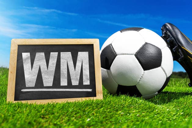 Germany - May 27, 2026: PHOTO MONTAGE, stock photo for the 2026 FIFA World Cup, WM, Weltmeisterschaft, Fussball A soccer ball lies on a field next to a sign reading World Cup. In the background, a blue sky and a soccer shoe on the grass. *** FOTOMONTAGE, Symbolfoto zur Fußball-Weltmeisterschaft 2026: Fußball liegt auf einem Spielfeld neben einer Tafel mit dem Schriftzug WM. Im Hintergrund blauer Himmel und Fußballschuh auf Rasen.