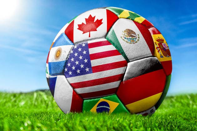 Germany - May 27, 2026: PHOTO MONTAGE, stock photo for the 2026 FIFA World Cup, WM, Weltmeisterschaft, Fussball - A soccer ball with various national flags on the field under a blue sky. The flags shown include those of the United States, Mexico, Canada, Spain, Brazil, and Argentina. *** FOTOMONTAGE, Symbolfoto zur Fußball-Weltmeisterschaft 2026 - Fußball mit verschiedenen Nationalflaggen auf Spielfeld Rasen unter blauem Himmel. Zu sehen sind unter anderem die Flaggen der USA, Mexikos, Kanadas, Spaniens, Brasiliens und Argentiniens.