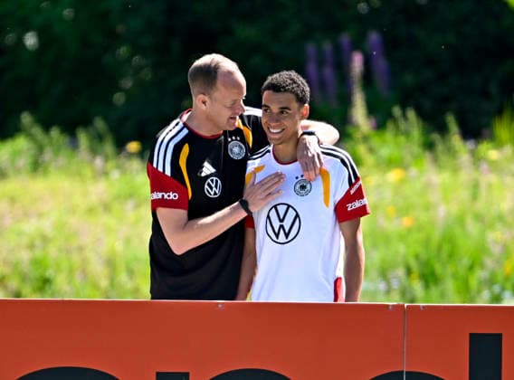 28.05.2026, Fussball DFB-Nationalmannschaft Deutschland, Trainingslager vor der WM in Herzogenaurach, im Homeground bei ADIDAS. Erste Trainingseinheit auf dem Adidas-Sportplatz, Dr Jochen Hahne (Deutschland) herzt Jamal Musiala (Deutschland)