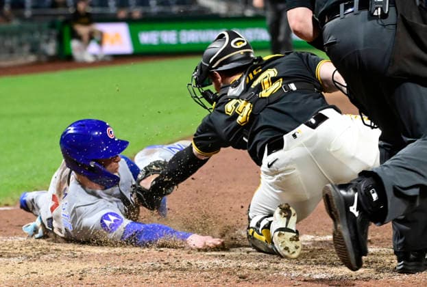 Chicago Cubs center fielder Pete Crow-Armstrong (4) reaches for the plate as Pittsburgh Pirates catcher Henry Davis (32) attempts the tag , the Chicago Cubs wins the challenge overturning the original out call in the ninth inning of the Cubs 7-2 win at PNC Park on Thursday, May 28, 2026 in Pittsburgh.  PIT2026052828 ArchiexCarpenter