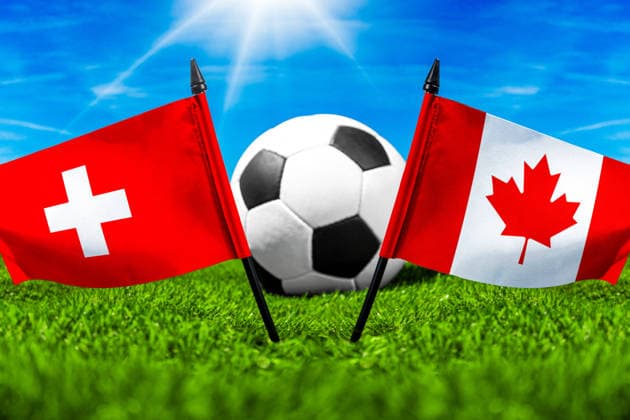 May 22, 2026: PHOTO MONTAGE, 2026 FIFA World Cup, WM, Weltmeisterschaft, Fussball National flags of Switzerland and Canada with a soccer ball on the field. Illustrative image for the group stage match on June 24 at the 2026 FIFA World Cup *** FOTOMONTAGE, Fußball-Weltmeisterschaft 2026: Nationalflaggen von Schweiz und Kanada mit Fußball auf Rasen. Symbolbild zum WM-Gruppenspiel am 24 Juni bei der FIFA Fussball-Weltmeisterschaft 2026