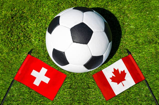 May 22, 2026: PHOTO MONTAGE, 2026 FIFA World Cup, WM, Weltmeisterschaft, Fussball National flags of Switzerland and Canada with a soccer ball on the field. Illustrative image for the group stage match on June 24 at the 2026 FIFA World Cup *** FOTOMONTAGE, Fußball-Weltmeisterschaft 2026: Nationalflaggen von Schweiz und Kanada mit Fußball auf Rasen. Symbolbild zum WM-Gruppenspiel am 24 Juni bei der FIFA Fussball-Weltmeisterschaft 2026