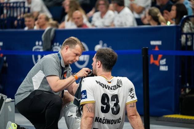 Veron Nacinovic ( 93; THW Kiel) kniet am Spielfeldrand und wird von einem Betreuer am Hals Kinn versorgt. Im Hintergrund sind Zuschauer der EHF European League Finals zu sehen. EHF European League: THW Kiel - Montpellier HB, 30.05.2026, Hamburg, Barclays Arena Copyright: xPhilippHeistx