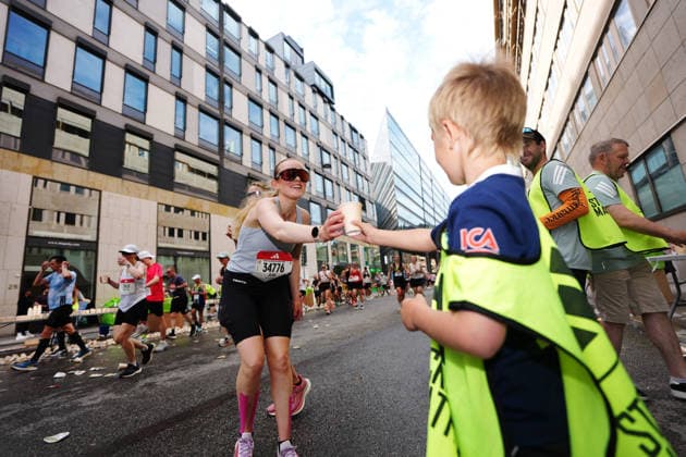 STOCKHOLM, SVERIGE 20260530 Axel, 6-ar, delar ut vatten under Stockholm marathon pa lördagen. STOCKHOLM SVERIGE x10500x