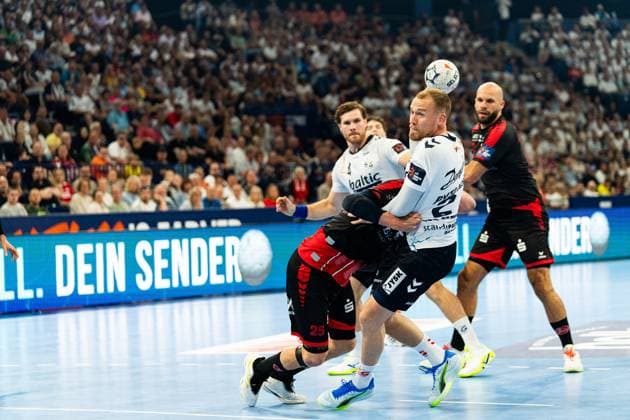 Kent Robin Tonnesen ( 23; SG Flensburg Handewitt) kämpft sich mit dem Ball durch die Abwehr von MT Melsungen, während Johannes Golla ( 3; SG Flensburg Handewitt) und Adrián Sipos ( 8; MT Melsungen) im Hintergrund zu sehen sind. Der MT-Spieler 25 Olle Forsell Schefvert versucht den Angriff zu stoppen. MT Melsungen vs SG Flensburg-Handewitt – EHF Finals Hamburg 2026 Copyright: xPhilippHeistx