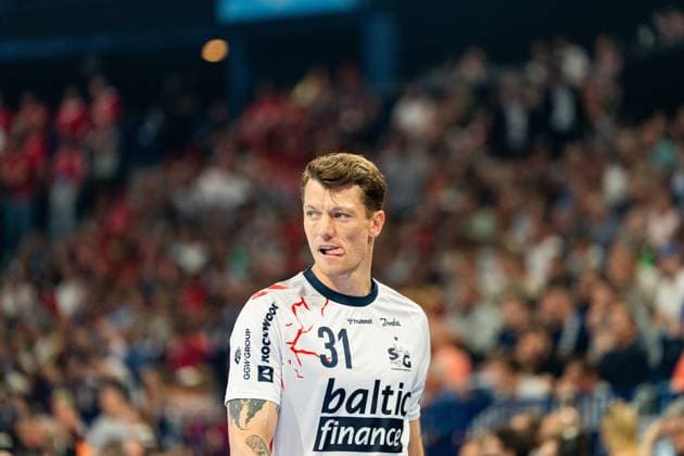 Emil Jakobsen ( 31; SG Flensburg Handewitt) blickt konzentriert zur Seite, im Hintergrund sind Zuschauer in der vollbesetzten Arena zu sehen. Der Linksaußen zeigt eine intensive Mimik während des Spiels. MT Melsungen vs SG Flensburg-Handewitt – EHF Finals Hamburg 2026 Copyright: xPhilippHeistx