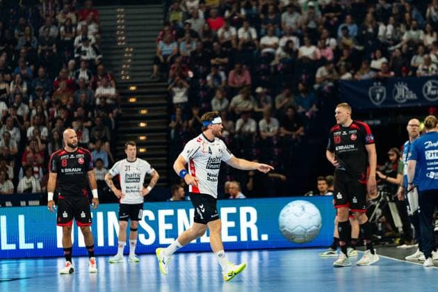 Adrian Sipos ( 8; MT Melsungen) steht am linken Bildrand, während ein Spieler der SG Flensburg-Handewitt mit 31 (Emil Jakobsen) und ein weiterer Flensburger Spieler mit 4 im Mittelpunkt der Szene agieren. Im Hintergrund ist ein gefülltes Publikum zu sehen. MT Melsungen vs SG Flensburg-Handewitt – EHF Finals Hamburg 2026 Copyright: xPhilippHeistx