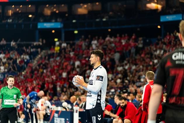 Marko Grgi? ( 17; SG Flensburg Handewitt) steht mit dem Handball in den Händen auf dem Spielfeld und bereitet eine Aktion vor. Im Hintergrund ist ein Schiedsrichter in grünem Trikot sowie Spieler von MT Melsungen zu sehen. MT Melsungen vs SG Flensburg-Handewitt – EHF Finals Hamburg 2026 Copyright: xPhilippHeistx