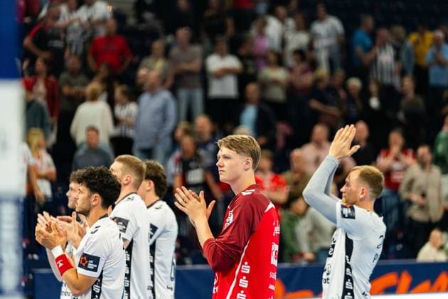 Moritz Frederik Detlefsen ( 18; SG Flensburg Handewitt) steht in einem dunkelroten Trikot neben Mitspielern der SG Flensburg Handewitt und applaudiert in Richtung der Zuschauer. Im Hintergrund ist eine gut gefüllte Tribüne zu sehen. MT Melsungen vs SG Flensburg-Handewitt – EHF Finals Hamburg 2026 Copyright: xPhilippHeistx