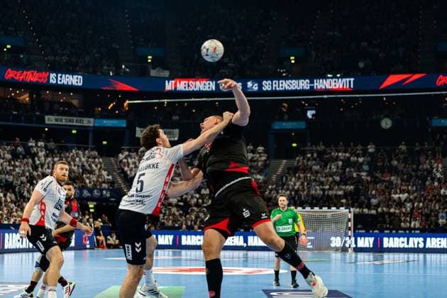 Niclas Kirkelokke ( 5; SG Flensburg Handewitt) wirft unter Bedrängnis eines Spielers von MT Melsungen auf das Tor, der Ball ist bereits in der Luft. Blaz Blagotinsek ( 43; SG Flensburg Handewitt) und Mohamed Amine Darmoul ( 71; MT Melsungen) sind im Hintergrund zu sehen. MT Melsungen vs SG Flensburg-Handewitt – EHF Finals Hamburg 2026 Copyright: xPhilippHeistx