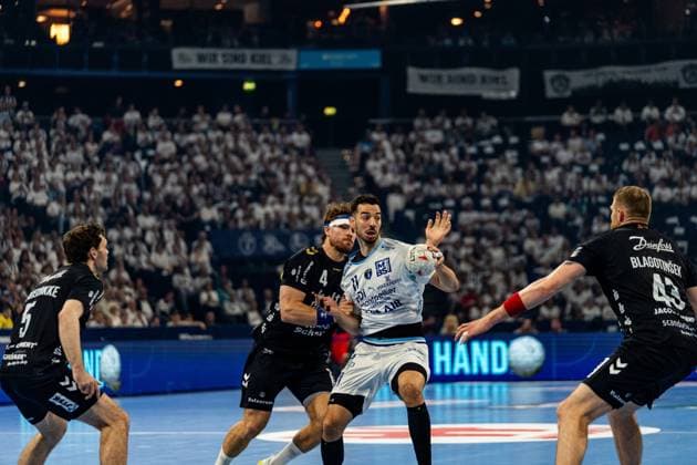 Zvonimir Srna ( 11; Montpellier HB) kämpft mit dem Ball in der Hand gegen die Abwehr der SG Flensburg Handewitt, darunter Adin Faljic ( 4; SG Flensburg Handewitt) und Blaz Blagotinsek ( 43; SG Flensburg Handewitt). Die vollbesetzte Arena bildet den Hintergrund des intensiven Zweikampfs. Zvonimir Srna ( 11; Montpellier HB) im Zweikampf gegen SG Flensburg Handewitt Copyright: xPhilippHeistx