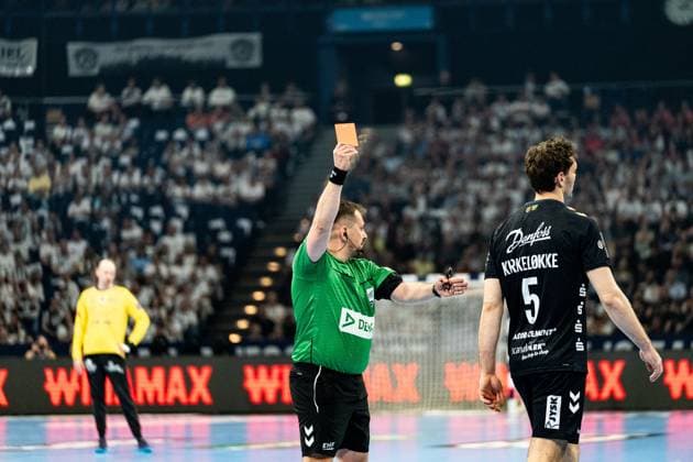 Ein EHF-Schiedsrichter zeigt Niclas Kirkelokke ( 5; SG Flensburg Handewitt) die Rote Karte. Im Hintergrund ist der Torwart von Montpellier HB im gelben Trikot zu sehen. Rote Karte für Niclas Kirkelokke ( 5; SG Flensburg Handewitt) Copyright: xPhilippHeistx