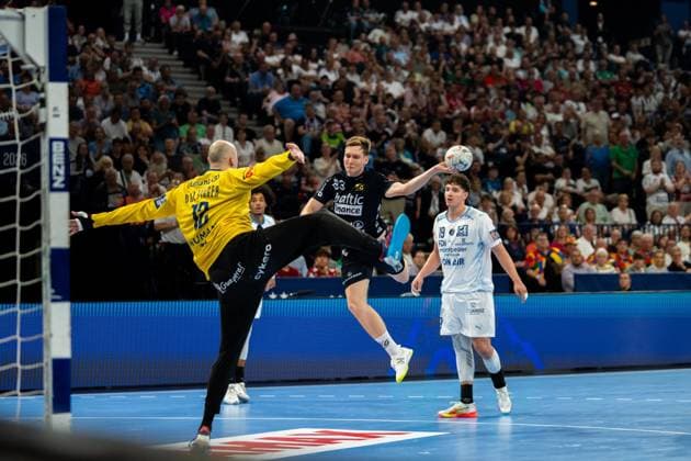 Domen Novak ( 63; SG Flensburg Handewitt) springt zum Wurf und wird von Torwart Charles Bolzinger ( 12; Montpellier HB) geblockt. Arthur Lenne ( 19; Montpellier HB) beobachtet die Szene im Hintergrund. Domen Novak ( 63; SG Flensburg Handewitt) beim Wurf gegen Montpellier HB Copyright: xPhilippHeistx