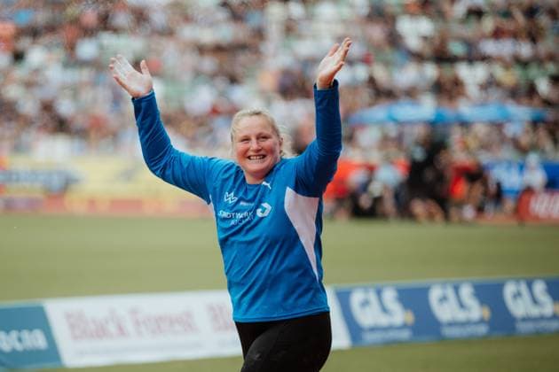 Alina Kenzel reißt beide Arme in die Höhe und jubelt ausgelassen nach ihrem Versuch im Kugelstossen. Im Hintergrund sind zahlreiche Zuschauer auf den Tribünen zu sehen. Alina Kenzel jubelt beim Kugelstossen im Stadion