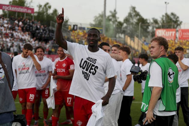 01.06.2026, Herren, Fussball, Saison 2025 2026, Relegation zur 3. Liga: FC Wuerzburger Kickers - 1. FC Lokomotive Leipzig Tarsis Bonga ( 30, FC Würzburger Kickers) trägt T-Shirt mit Aufschrift Jesus Loves You, Aufstiegsparty am Dallenberg Wuerzburg FLYERALARM Arena Bayern Deutschland