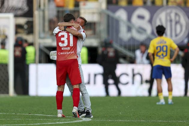 01.06.2026, Herren, Fussball, Saison 2025 2026, Relegation zur 3. Liga: FC Wuerzburger Kickers - 1. FC Lokomotive Leipzig Jubel über den Aufstieg: Tim Kraus ( 31, FC Würzburger Kickers) und Michael Schiele (Cheftrainer, FC Würzburger Kickers) umarmen sich Wuerzburg FLYERALARM Arena Bayern Deutschland
