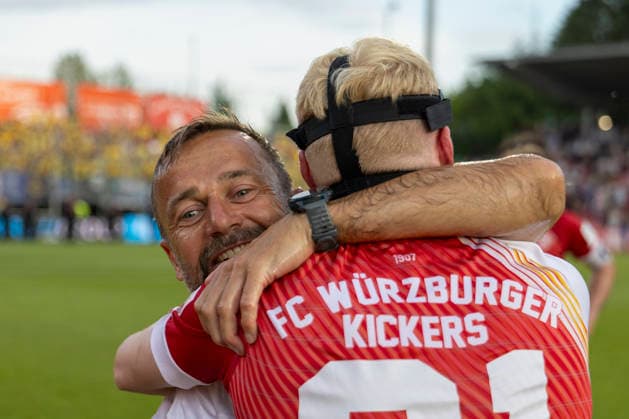 Trainer Michael Schiele des FC Würzburger Kickers umarmt seinen Spieler Philipp Ochs herzlich und emotional nach dem erfolgreichen Aufstieg in die 3. Liga. Die innige Szene zeigt die enge Bindung zwischen Trainer und Spieler sowie die große Freude über den gemeinsamen Erfolg, AKON Arena am Dallenberg, Würzburg, Deutschland, am 1. Juni 2026. DFB DFL REGULATIONS PROHIBIT ANY USE OF PHOTOGRAPHS AS IMAGE SEQUENCES AND OR QUASI-VIDEO, Copyright: HMBxMedia xHeikoxBecker