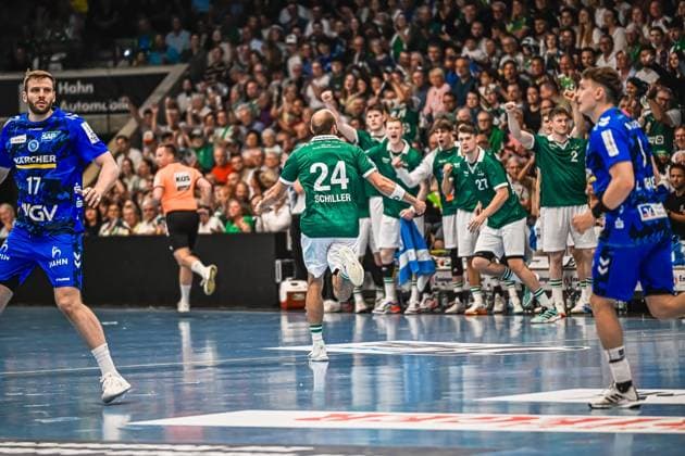Handball, HBL, Frisch Auf! Göppingen - TVB 1898 Stuttgart Spieler 24 Schiller von Frisch Auf! Göppingen läuft jubelnd in Richtung seiner feiernden Teamkollegen an der Seitenlinie. Links im Bild ein Spieler des TVB Stuttgart ( 17), rechts ein weiterer TVB-Spieler ( 2). Schiller ( 24; Frisch Auf! Göppingen) jubelt vor der Teambank