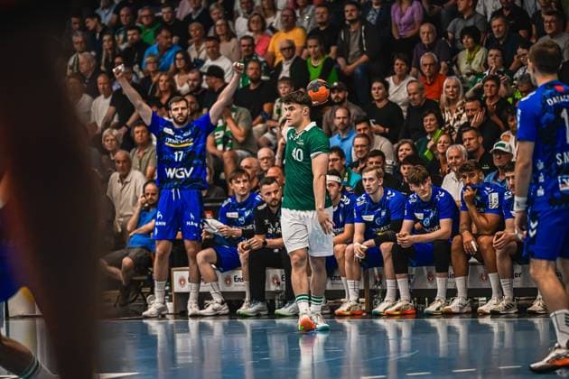 Handball, HBL, Frisch Auf! Göppingen - TVB 1898 Stuttgart Ein Spieler von Frisch Auf! Göppingen mit der Nummer 40 steht mit dem Ball in der Hand und bereitet einen Einwurf vor. Im Hintergrund ist die Bank von TVB Stuttgart zu sehen, darunter ein Spieler mit der Nummer 17 im blauen Trikot. Spieler ( 40; Frisch Auf! Göppingen) beim Einwurf gegen TVB Stuttgart
