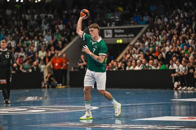 Handball, HBL, Frisch Auf! Göppingen - TVB 1898 Stuttgart Kasper Lien ( 7; TVB Stuttgart) holt zum Wurf aus und hält den Ball mit erhobener Hand über dem Kopf. Im Hintergrund ist ein Spieler von Frisch Auf! Göppingen mit Nummer 12 zu sehen. Kasper Lien ( 7; TVB Stuttgart) beim Wurf gegen Frisch Auf! Göppingen