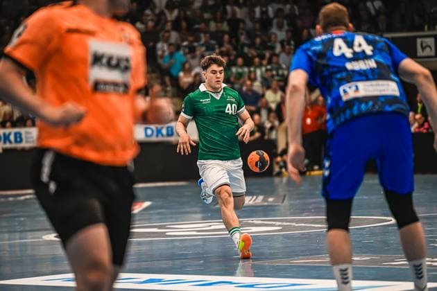 Handball, HBL, Frisch Auf! Göppingen - TVB 1898 Stuttgart Ein Spieler von Frisch Auf! Göppingen mit der Nummer 40 treibt den Ball durch die Abwehr des TVB Stuttgart. Rechts ist TVB-Spieler 44 zu sehen, links der Göppinger Torwart im orangenen Trikot. Spieler ( 40; Frisch Auf! Göppingen) im Angriff gegen TVB Stuttgart