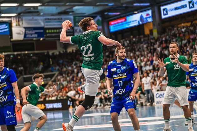 Handball, HBL, Frisch Auf! Göppingen - TVB 1898 Stuttgart #2 Spieler 22 Person von Frisch Auf! Göppingen zieht zum Sprungwurf hoch, während ein Spieler des TVB Stuttgart ( 17) die Abwehr organisiert. Im Hintergrund verfolgen weitere Spieler beider Teams die Aktion vor ausverkauftem Haus. Person ( 22; Frisch Auf! Göppingen) beim Sprungwurf gegen TVB Stuttgart