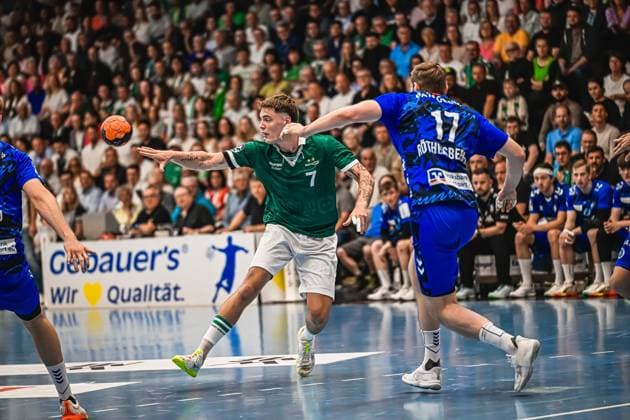 Handball, HBL, Frisch Auf! Göppingen - TVB 1898 Stuttgart #2 Kasper Lien ( 7; TVB Stuttgart) zieht in grünem Trikot zum Wurf auf das Tor, während ein Spieler von Frisch Auf! Göppingen mit der Rückennummer 17 (Röthlisberger) versucht, den Wurf zu blocken. Der Handball ist bereits in der Luft. Kasper Lien ( 7; TVB Stuttgart) beim Wurf gegen Frisch Auf! Göppingen