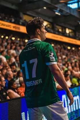 Handball, HBL, Frisch Auf! Göppingen - TVB 1898 Stuttgart #2 Spieler Gossner ( 17) von Frisch Auf! Göppingen steht mit dem Rücken zur Kamera in der vollbesetzten Arena. Das Trikot zeigt den Schriftzug 130 Jahre Edition Grün-Weiß sowie das HBL-Logo. Gossner ( 17; Frisch Auf! Göppingen) in der EWS Arena