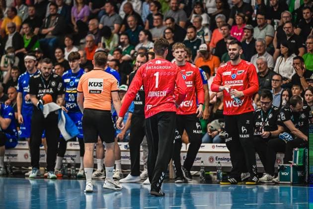 Handball, HBL, Frisch Auf! Göppingen - TVB 1898 Stuttgart #2 TVB-Stuttgart-Torwart Kornecki ( 1) steht mit einem Mitspieler auf dem Spielfeld nahe der Seitenlinie. Ein Schiedsrichter in orangefarbenem Trikot ist ebenfalls im Bild zu sehen. Kornecki ( 1; TVB Stuttgart) an der Seitenlinie im Gespräch