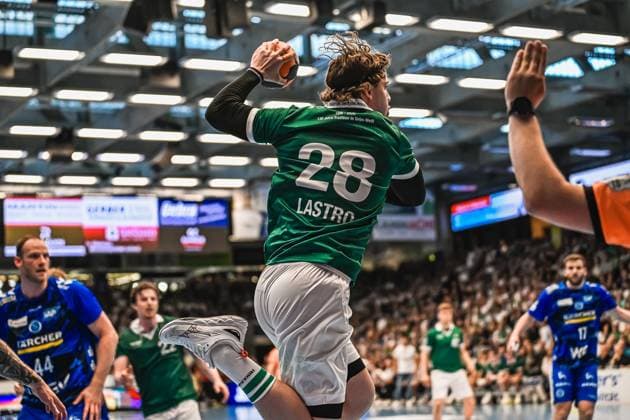 Handball, HBL, Frisch Auf! Göppingen - TVB 1898 Stuttgart #3 Franko Lastro ( 28; Frisch Auf! Göppingen) springt ab und zieht zum Wurf hoch, während Lenny Rubin ( 44; TVB Stuttgart) links im Bild als Abwehrspieler zu sehen ist. Rechts am Bildrand ist der ausgestreckte Arm eines Schiedsrichters erkennbar. Franko Lastro ( 28; Frisch Auf! Göppingen) beim Wurf gegen TVB Stuttgart
