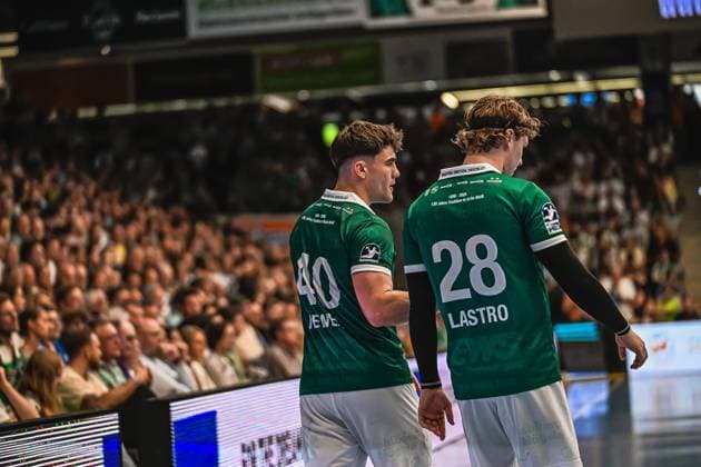 Handball, HBL, Frisch Auf! Göppingen - TVB 1898 Stuttgart #3 Elias Newel ( 40; Frisch Auf! Göppingen) und Franko Lastro ( 28; Frisch Auf! Göppingen) stehen mit dem Rücken zur Kamera auf der Seitenlinie. Im Hintergrund ist eine gut gefüllte Zuschauerkulisse zu sehen. Elias Newel ( 40) und Franko Lastro ( 28; Frisch Auf! Göppingen) auf der Seitenlinie
