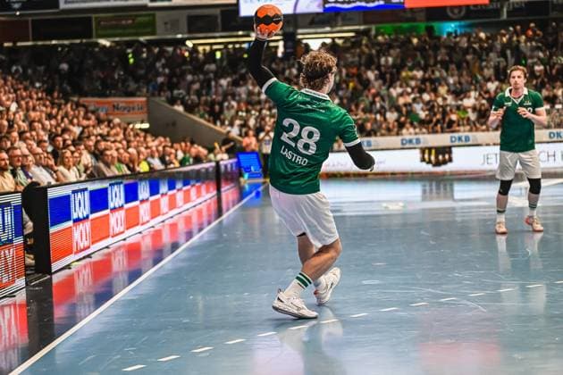 Handball, HBL, Frisch Auf! Göppingen - TVB 1898 Stuttgart #3 Franko Lastro ( 28; Frisch Auf! Göppingen) springt von der rechten Außenposition ab und wirft den Ball in Richtung Tor. Im Hintergrund ist ein weiterer Göppingen-Spieler in grünem Trikot zu sehen, die vollbesetzte Halle bildet die Kulisse. Franko Lastro ( 28; Frisch Auf! Göppingen) beim Wurf von der Außenposition
