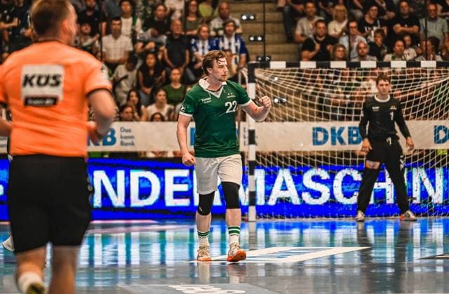 Handball, HBL, Frisch Auf! Göppingen - TVB 1898 Stuttgart #3 Erik Persson ( 22; Frisch Auf! Göppingen) läuft jubelnd mit geballter Faust über das Spielfeld. Im Hintergrund ist ein Torwart im schwarzen Trikot sowie ein Schiedsrichter in Orange zu sehen. Erik Persson ( 22; Frisch Auf! Göppingen) bejubelt Torerfolg