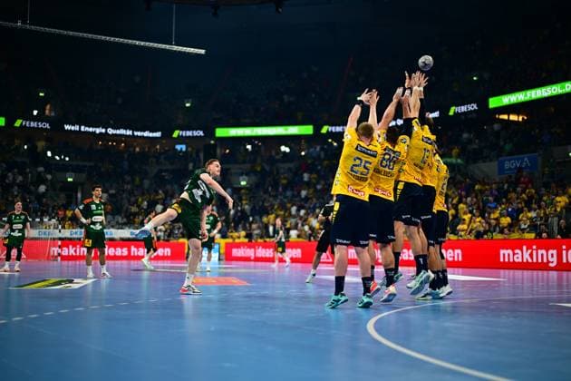 Handball, HBL, Rhein-Neckar Löwen - TSV Hannover-Burgdorf #4 Ein Spieler von TSV Hannover-Burgdorf springt zum Wurf und überwindet dabei die Abwehrmauer der Rhein Neckar Löwen, in der Haukur Thrastarson ( 25), Jannik Kohlbacher ( 80) und weitere Spieler die Arme hochreißen. Der Ball ist bereits in der Luft über dem Block. TSV Hannover-Burgdorf Wurf gegen Rhein Neckar Löwen Abwehrblock Copyright: xMichaelxGelhardtx