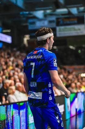 Handball, HBL, Frisch Auf! Göppingen - TVB 1898 Stuttgart #5 Kasper Thorsen Lien ( 7; TVB Stuttgart) steht mit dem Rücken zur Kamera an der Seitenlinie vor vollbesetzten Zuschauerrängen. Der Rechtsaußen trägt ein weißes Stirnband. Kasper Thorsen Lien ( 7; TVB Stuttgart) an der Seitenlinie