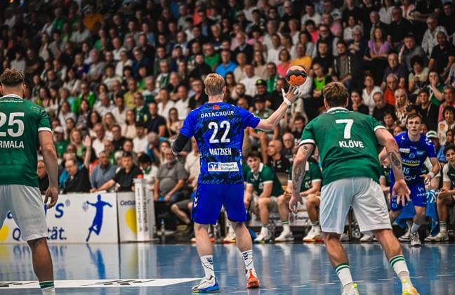 Handball, HBL, Frisch Auf! Göppingen - TVB 1898 Stuttgart #5 Torben Matzken ( 22; TVB Stuttgart) hält den Ball hoch und sucht eine Wurfmöglichkeit, während Victor Klöve ( 7; Frisch Auf! Göppingen) in der Abwehr steht. Links im Bild ist ein weiterer Spieler von Frisch Auf! Göppingen mit der Nummer 25 zu sehen. Torben Matzken ( 22; TVB Stuttgart) im Angriff gegen Victor Klöve ( 7; Frisch Auf! Göppingen)