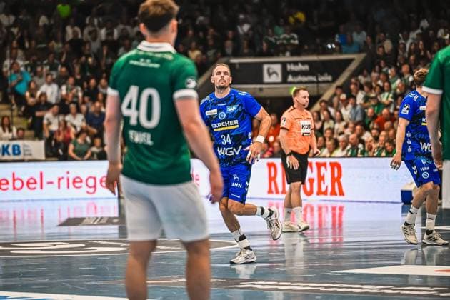 Handball, HBL, Frisch Auf! Göppingen - TVB 1898 Stuttgart #5 Kai Häfner ( 34; TVB Stuttgart) läuft in der vollbesetzten EWS-Arena in Richtung Spielfeld und beobachtet das Geschehen. Im Vordergrund ist Elias Newel ( 40; Frisch Auf! Göppingen) von hinten zu sehen, im Hintergrund agiert ein Schiedsrichter. Kai Häfner ( 34; TVB Stuttgart) im Spielgeschehen gegen Frisch Auf! Göppingen